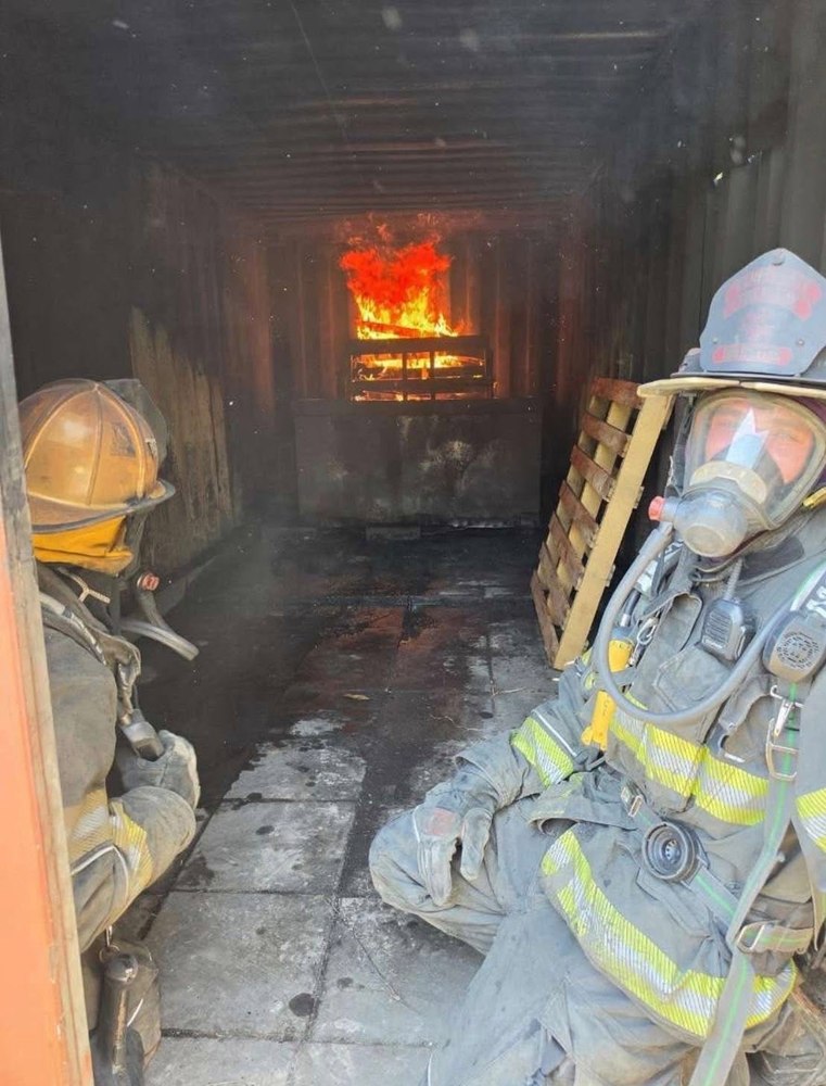 Firefighters in a live-fire training burn container