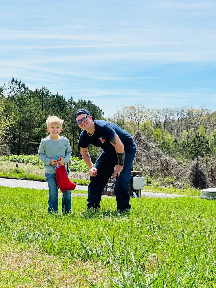 Gilmer County Fire/Rescue firefighter with a child at a community event