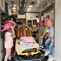 Kids touring the back of a Gilmer County Fire/Rescue ambulance at a community event