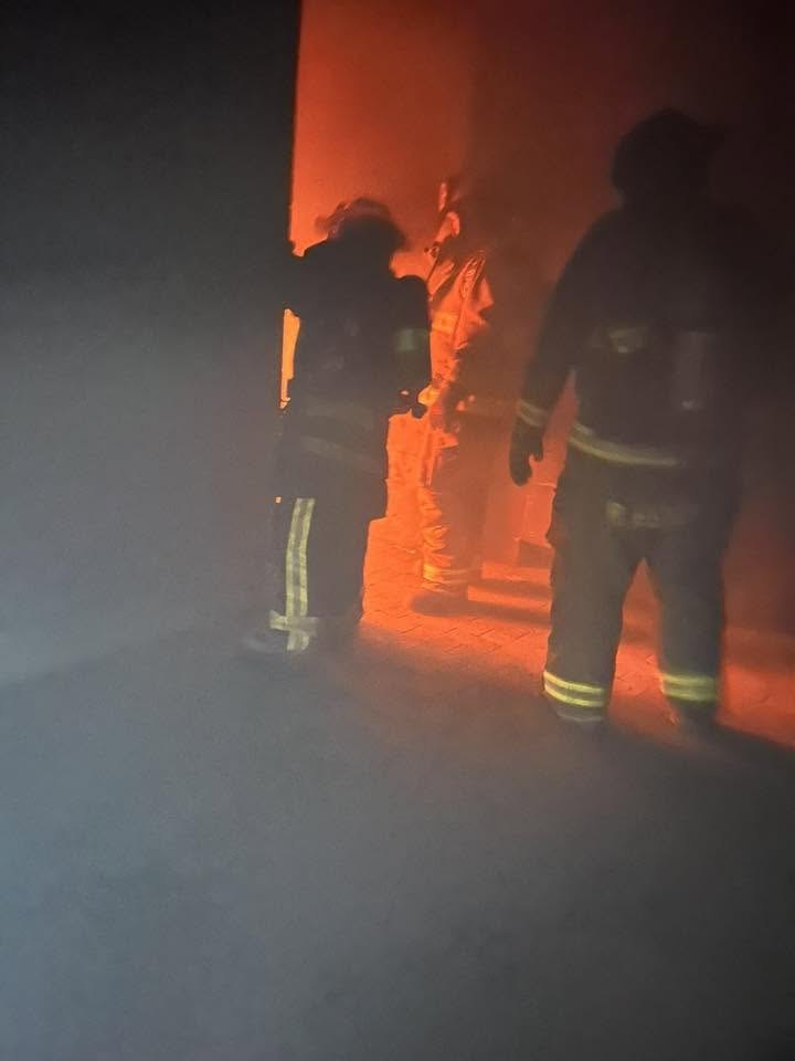 Firefighters silhouetted against flames during live-fire training