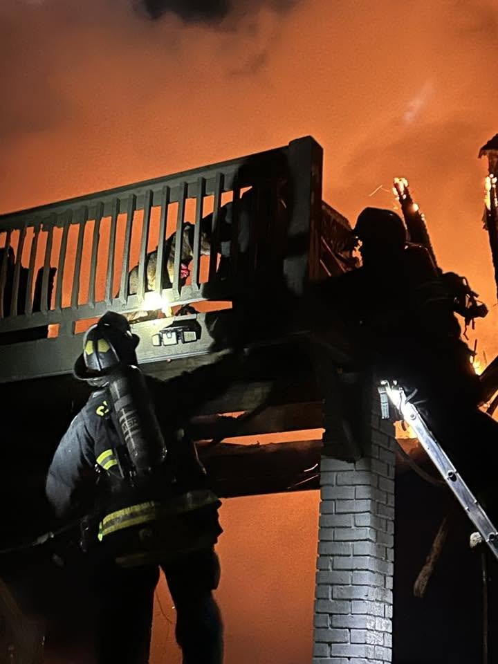 Firefighter advancing a hoseline toward an active structure fire