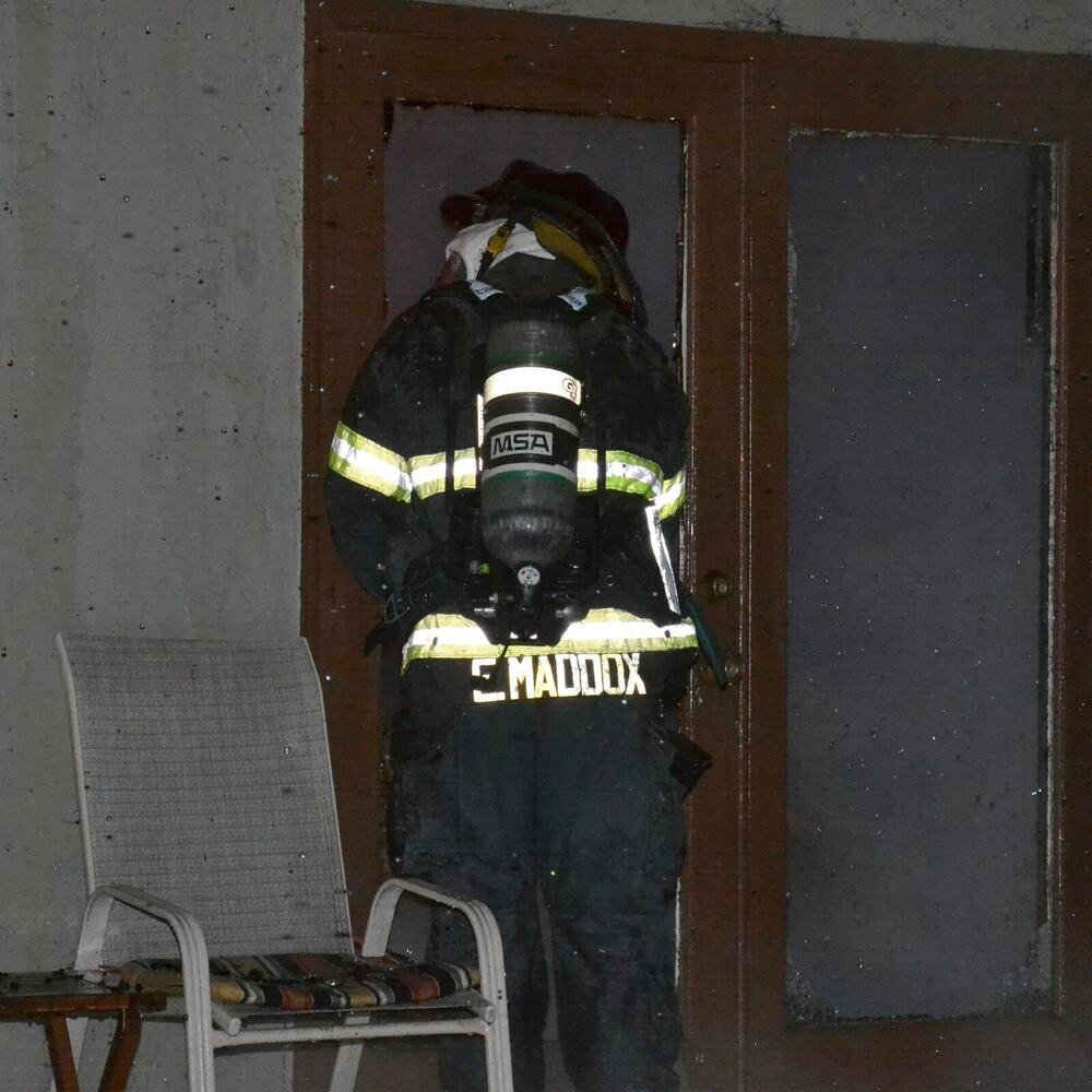 Eric Maddox in full turnout gear and SCBA, entering a structure