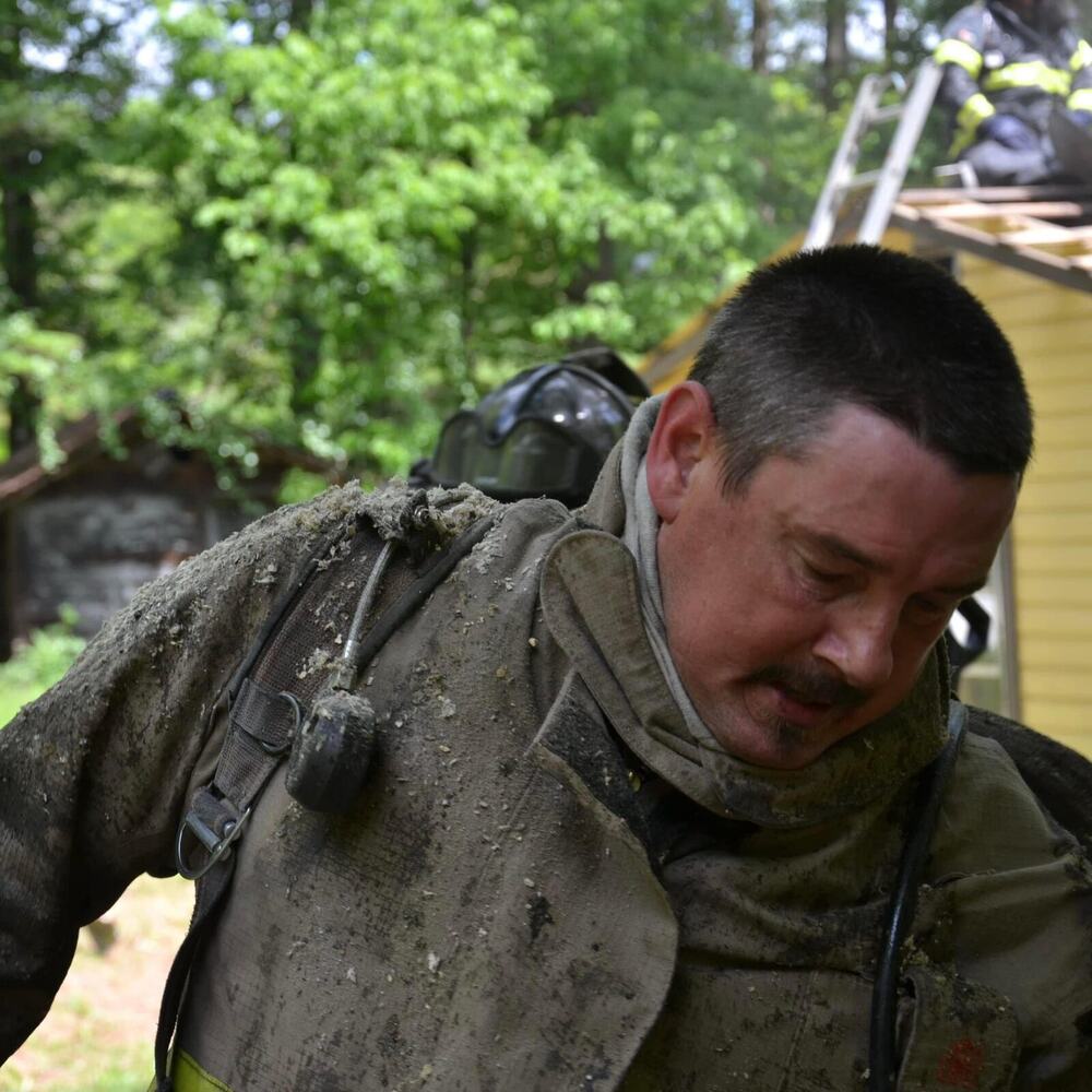 Close-up of Eric Maddox in dust-covered turnout gear