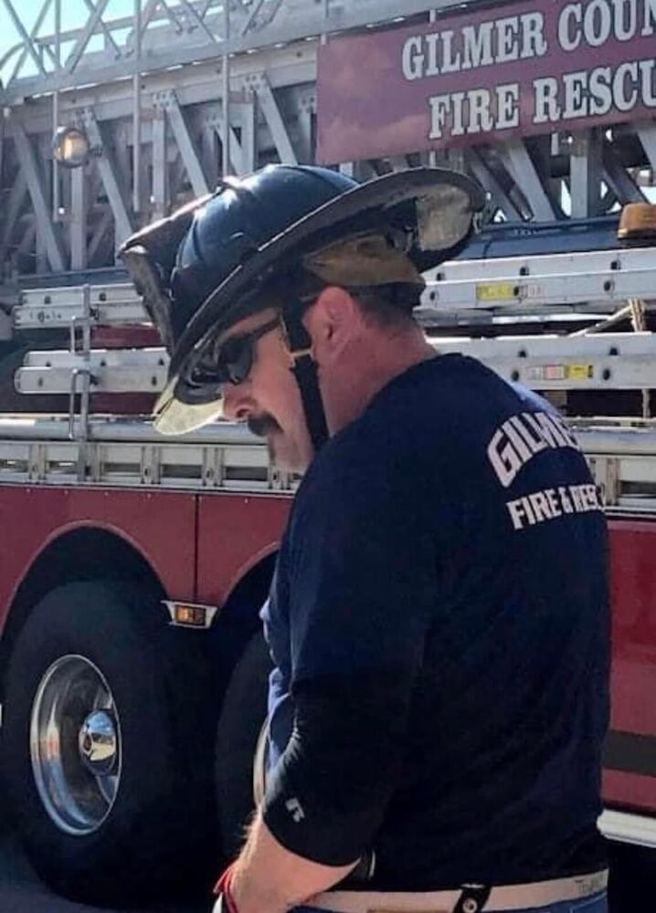 Eric Maddox beside a Gilmer County Fire Rescue ladder truck