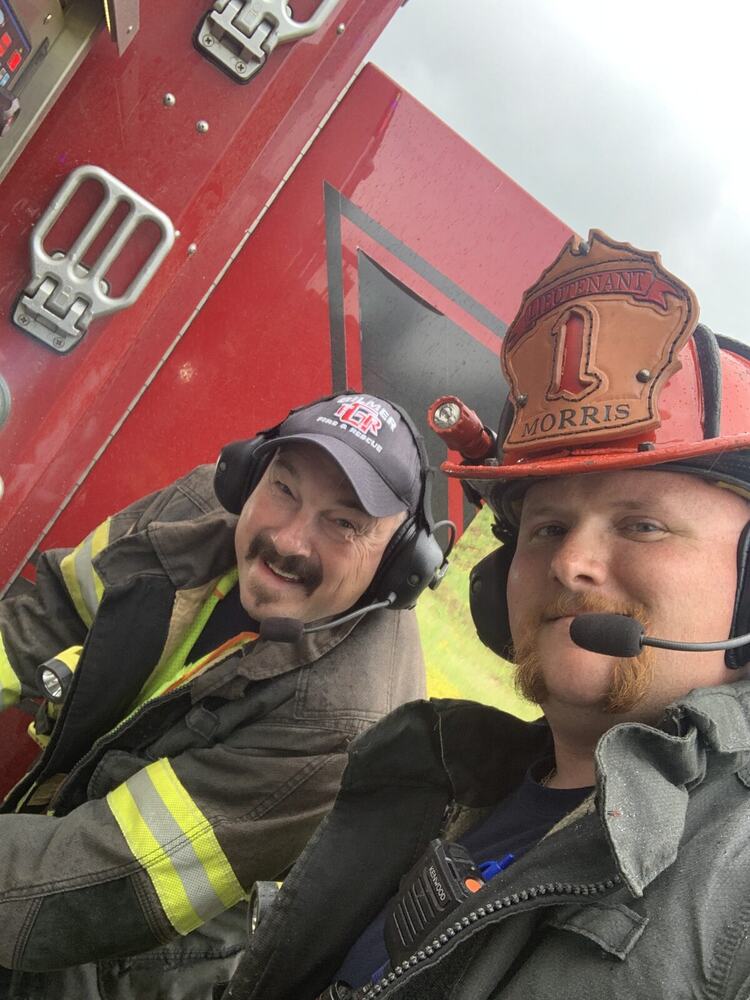 Eric Maddox with a fellow Gilmer County Fire Rescue firefighter on the apparatus
