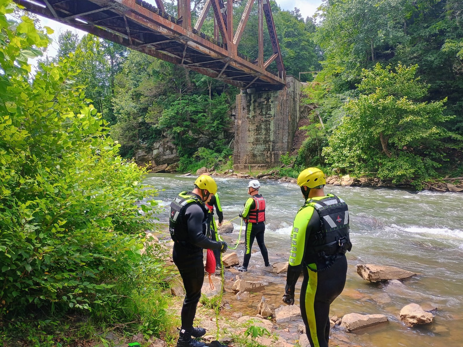 Gilmer County Fire/Rescue swift water rescue team on the river beneath a historic rail trestle